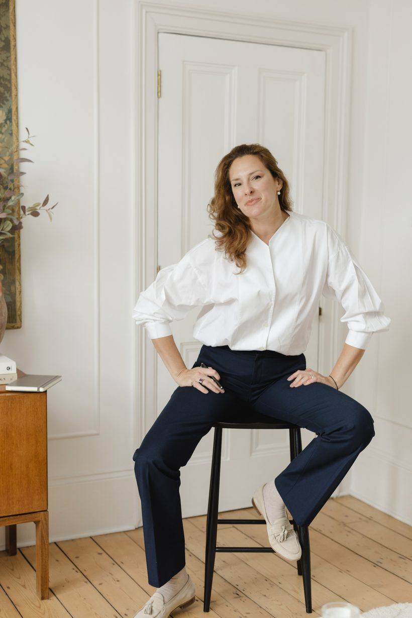 Anastasia Roumelioti seated on a stool, facing the camera