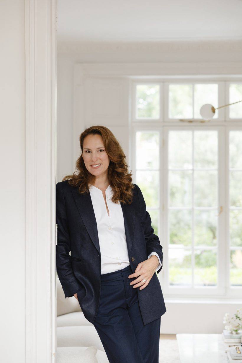 Anastasia Roumelioti in a navy suit, standing in a panelled doorway