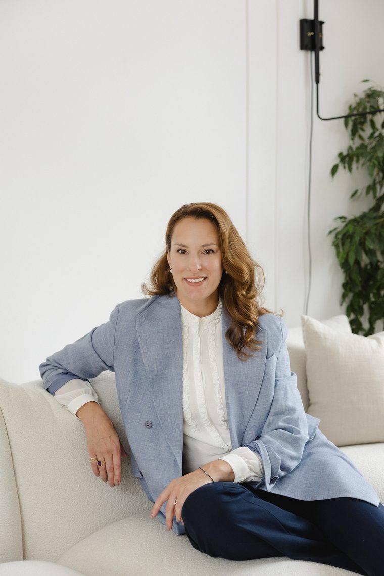 Anastasia Roumelioti seated, in a light blue blazer